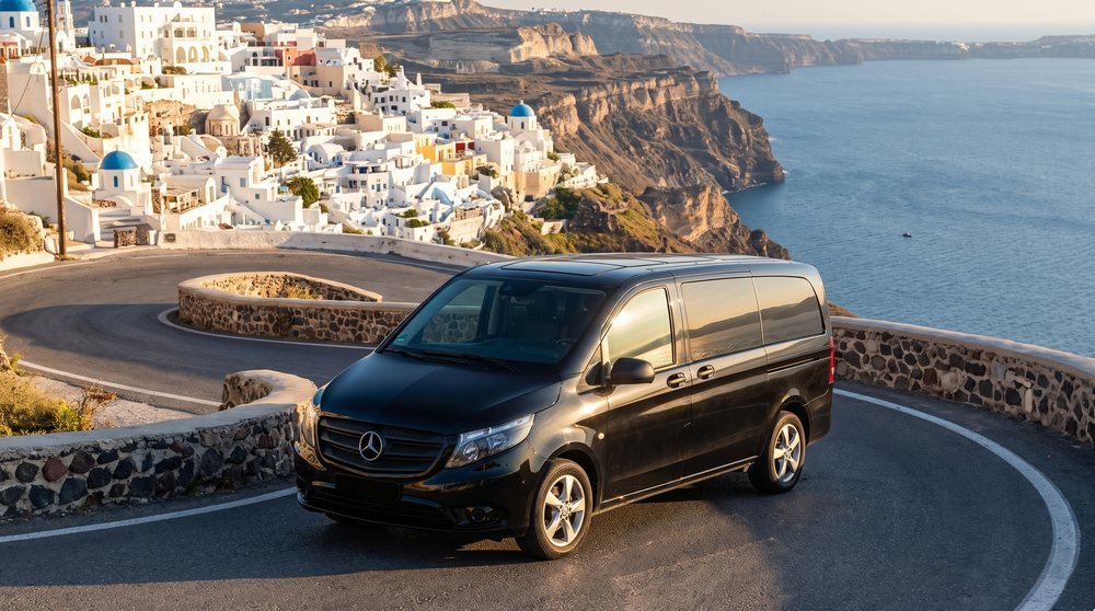 Black Mercedes VIP van on a Santorini caldera road